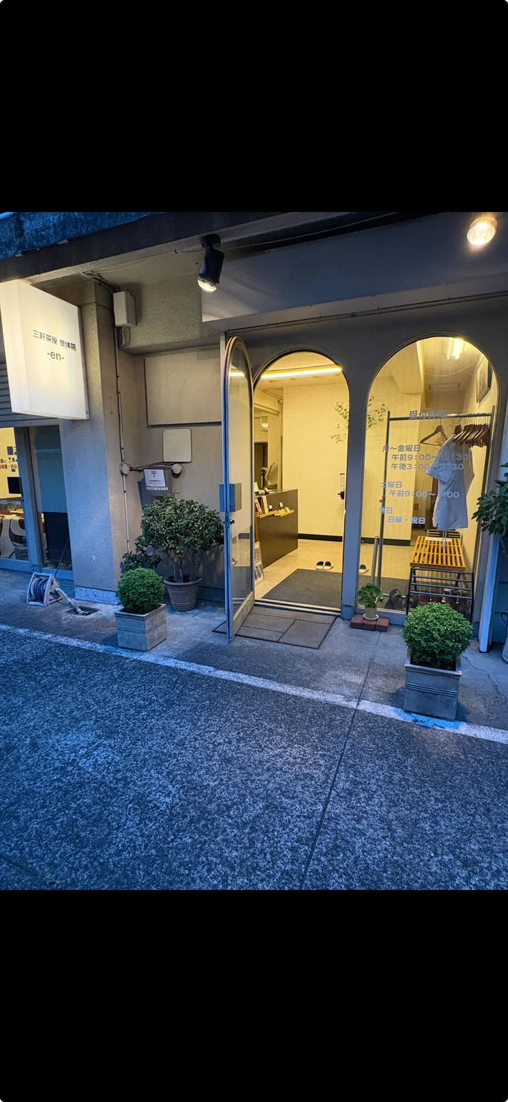 夜の院の入口。白い看板と鉢植えが並んでいる